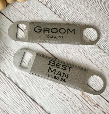 Two bottle openers with engraved text on a wooden surface