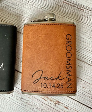 Brown leather flask with 'Groomsman Jack 10.14.25' engraving on a wooden surface