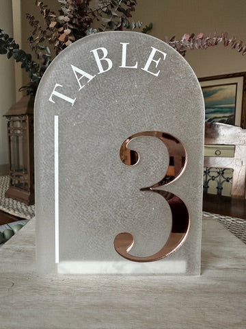 Table number 3 on a stone pedestal with decorative elements in the background