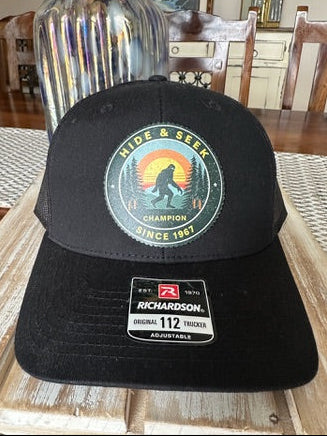 Black cap with a logo on a wooden table