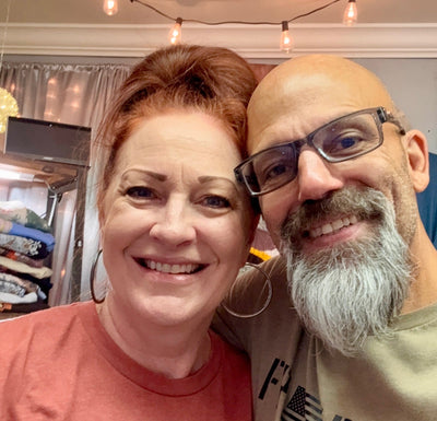 Two people posing together with string lights in the background